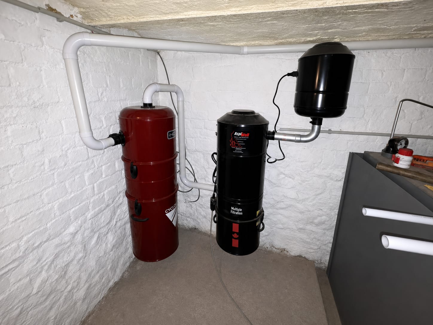 On the left the burgundy Cyclovac HD cyclonic interceptor, on the right the AspiWall S500 central unit — customer installation in Beaumont